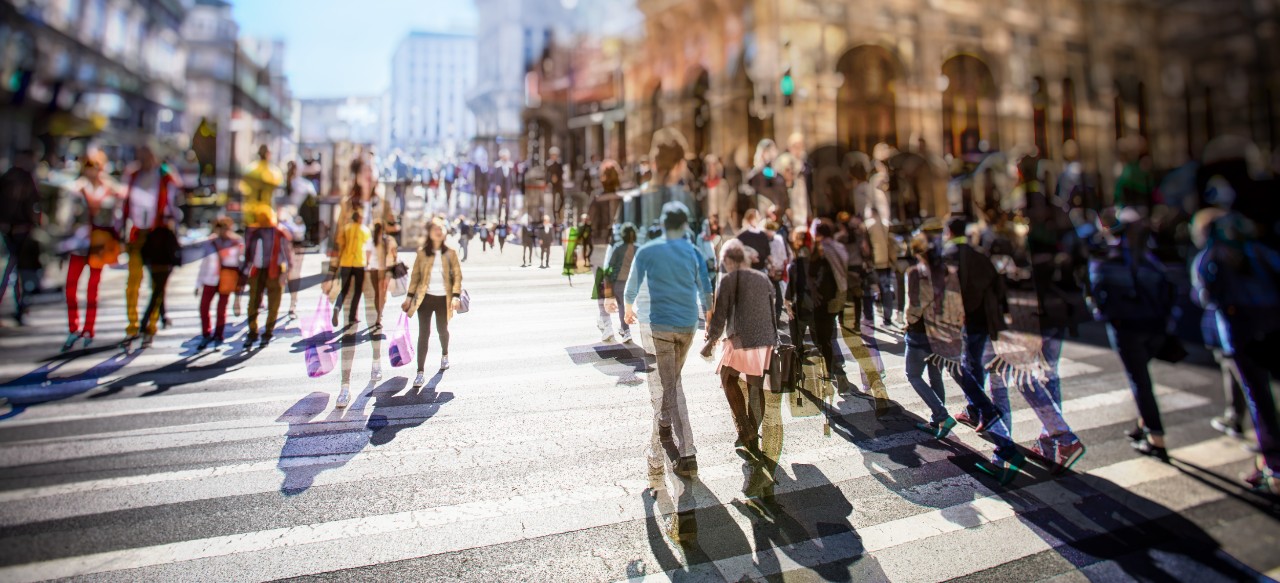 Busy Pedestrian Crossing over zebra on sunny day in the city 